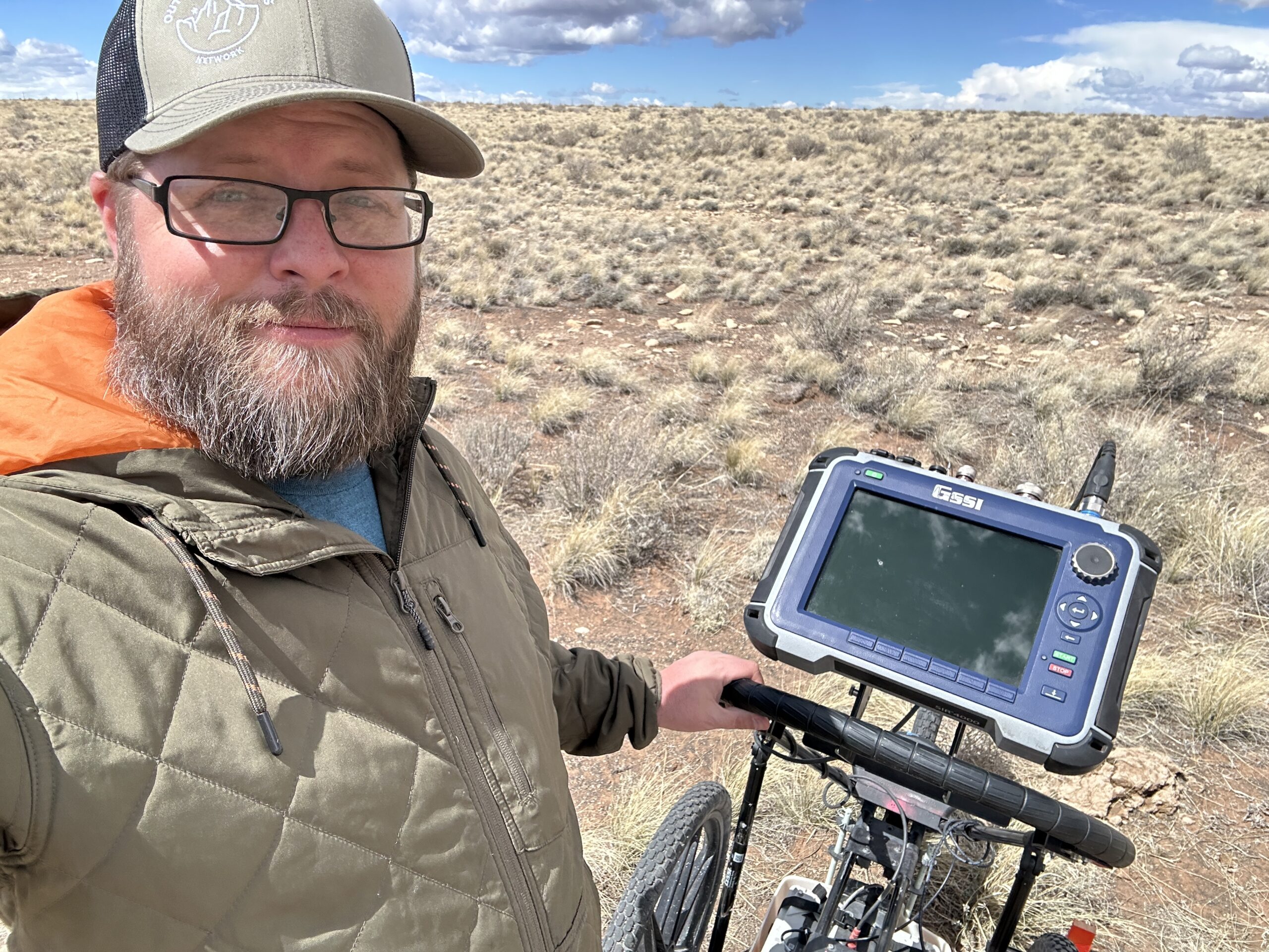 Nate Loper beside ground-penetrating radar equipment during field research in Arizona
