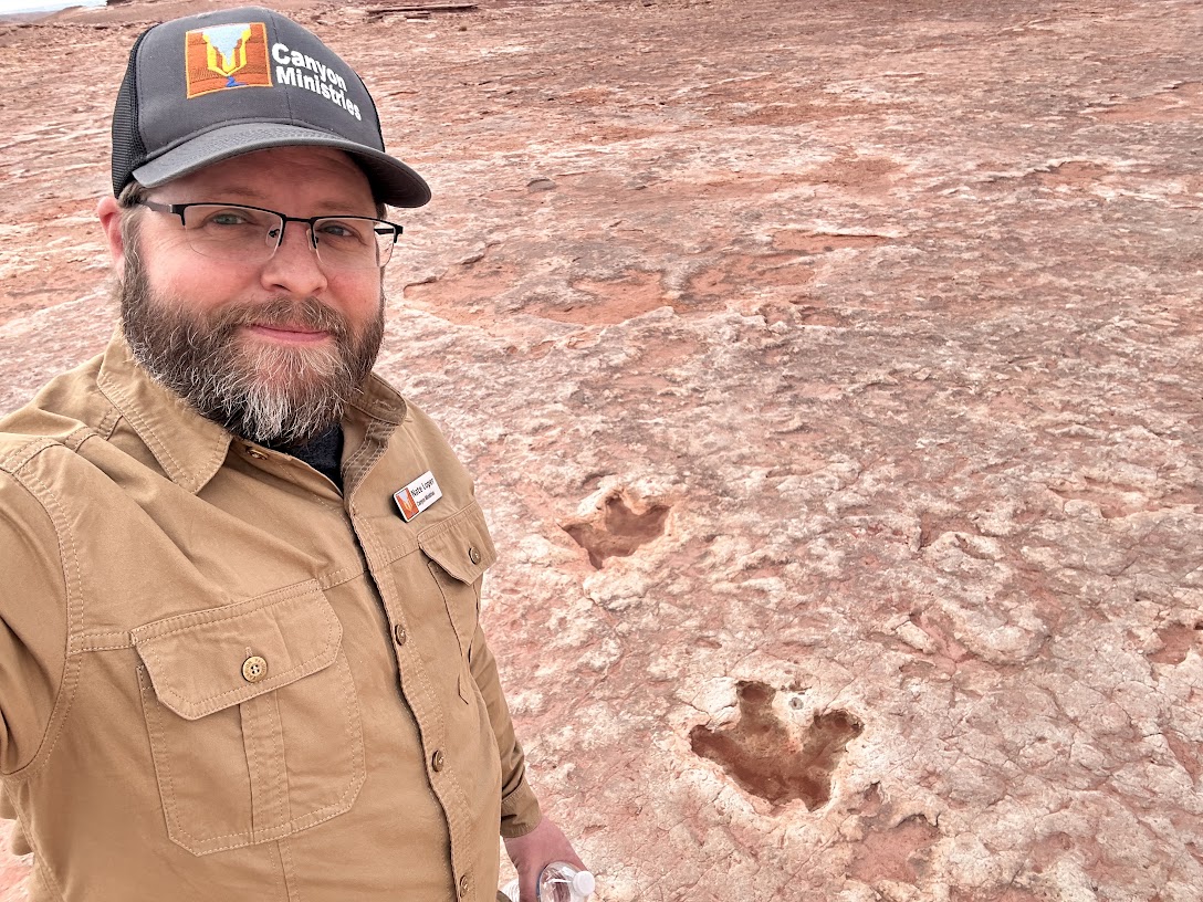 Nate Loper Examining Fossil Trackways Nate Loper beside fossil track impressions preserved in sandstone