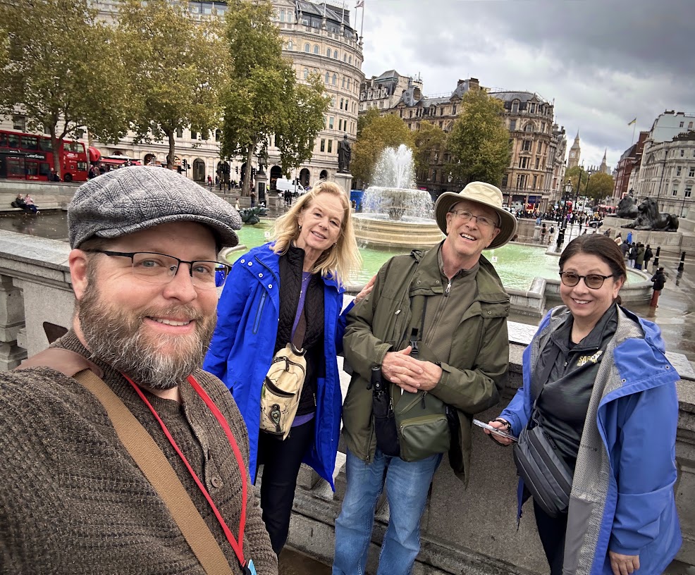 Nate Loper with three tour guests at Trafalgar Square in London