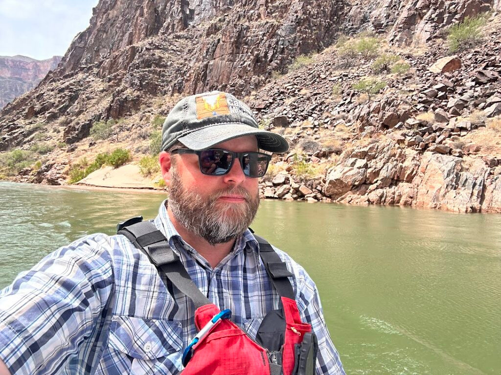 Nate Loper wearing a life jacket on the Colorado River in Grand Canyon